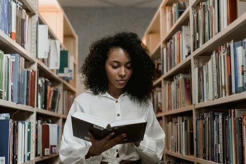 Student reading a book in the library.