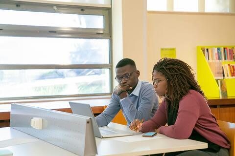 students performing research on a laptop