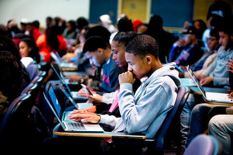Image of students programming on laptops
